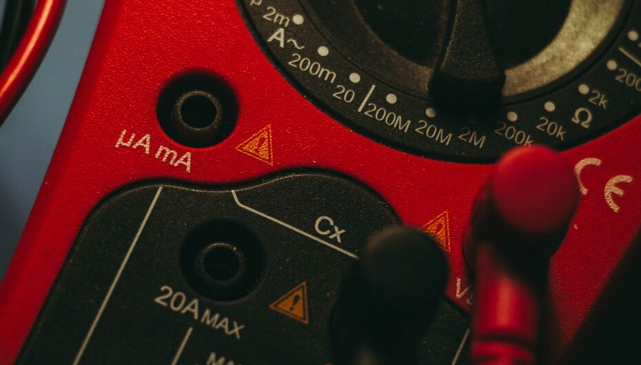 Zbliżenie na pokrętło i gniazda pomiarowe miernika elektrycznego z oznaczeniami zakresów